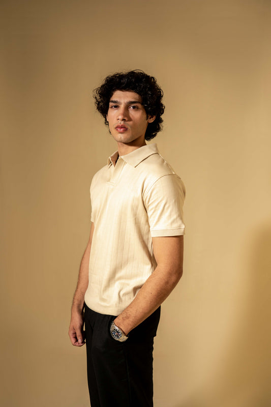 Man wearing a light-colored polo shirt against a beige background