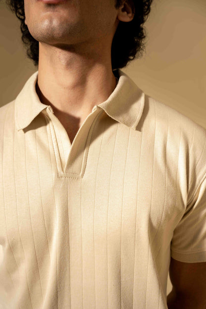 Close-up of a person wearing a beige polo shirt with a blurred background