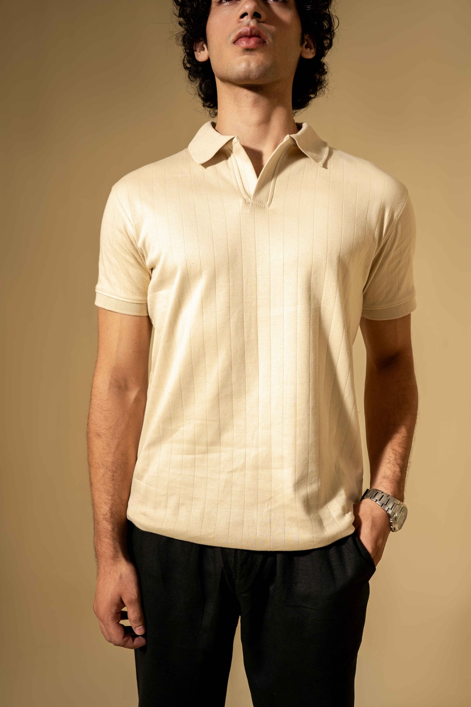 Man wearing a beige polo shirt against a beige background