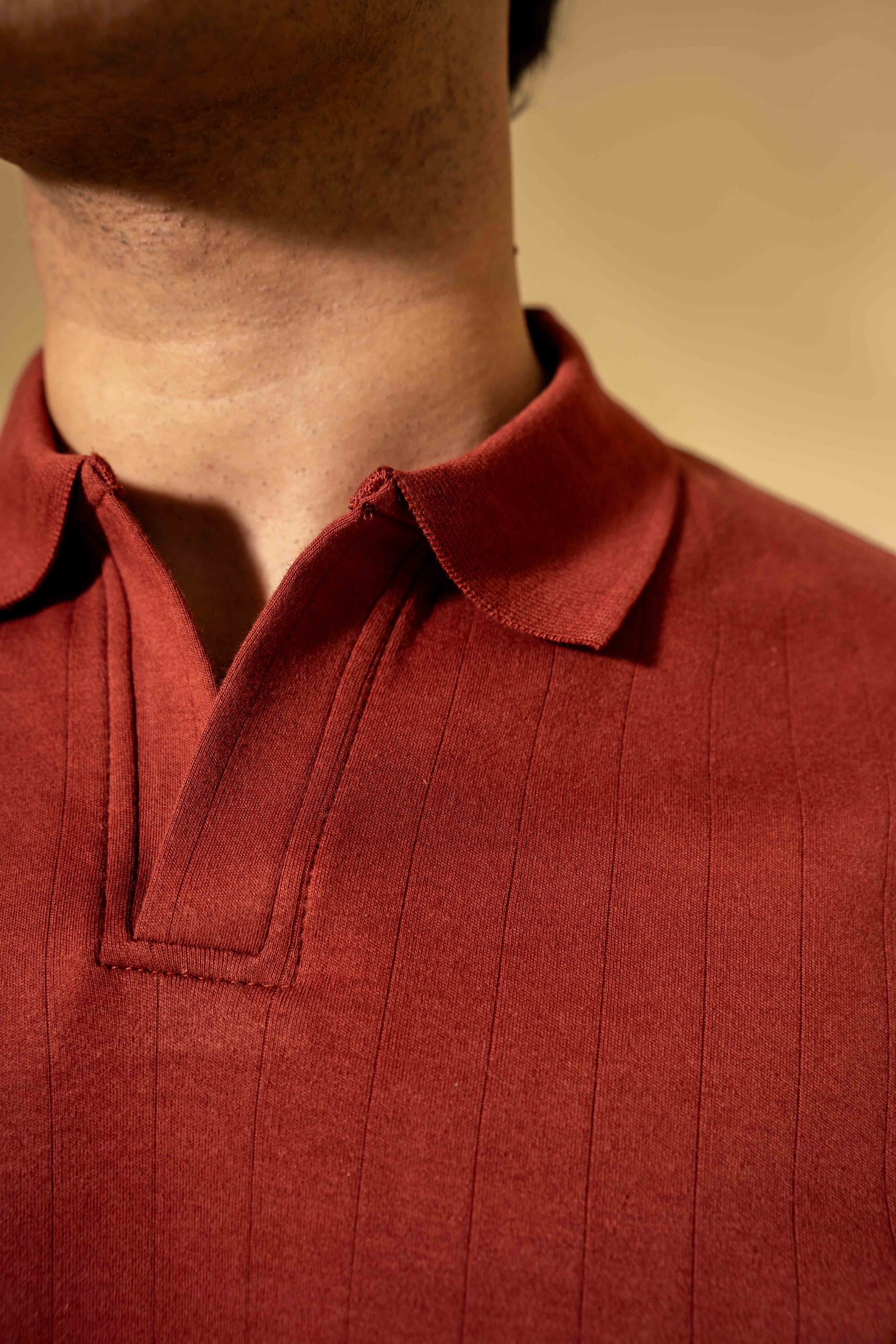 Close-up of a person wearing a red polo shirt with a blurred background