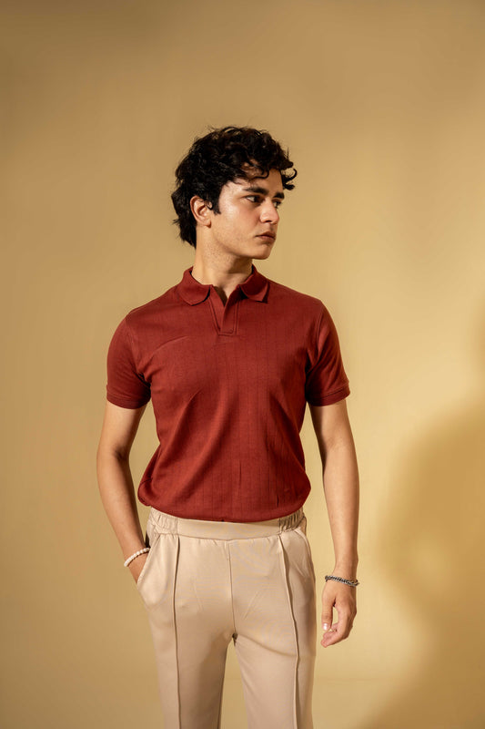 Man wearing a red polo shirt and beige pants against a beige background